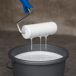 Primerroller die uit een emmer met voorstrijk wordt gehaald terwijl primer terug druipt op een betonnen vloer
